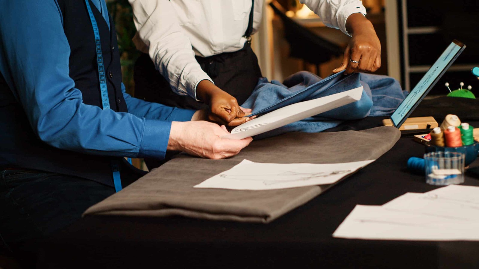 ld craftsman teaching apprentice tailoring skills with fabric