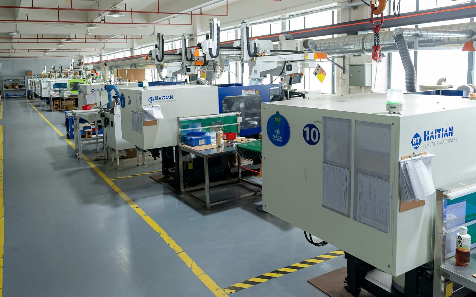 Plastic injection molding machines operating inside modern factory